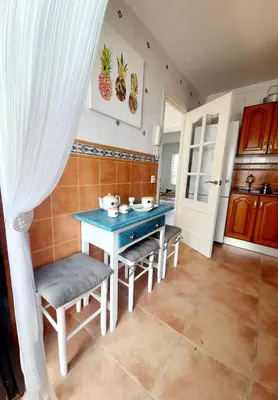 a kitchen with a blue table and some chairs at Villa Lolera in Chiclana de la Frontera
