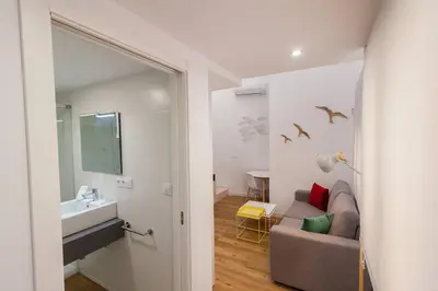 a bathroom with a couch and a sink in a room at El Duplex de Barrocal in Cádiz