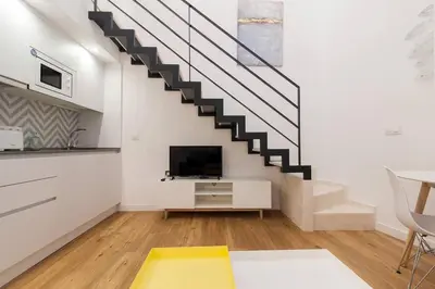 a living room with a staircase and a tv at El Duplex de Barrocal in Cádiz
