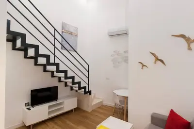 a living room with a staircase and a tv at El Duplex de Barrocal in Cádiz
