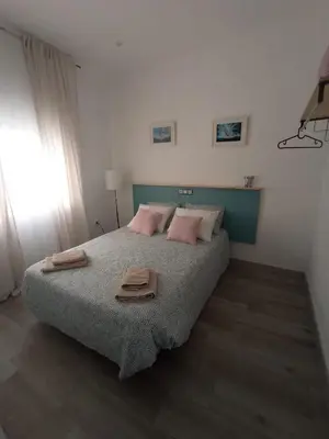 a bedroom with a bed with two towels on it at Casa Reyes in Rota