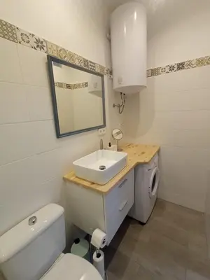 a bathroom with a sink and a toilet and a mirror at Casa Reyes in Rota