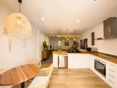 a kitchen with white cabinets and a wooden table at La Primera de Occidente in Cádiz