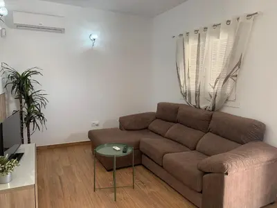 a living room with a brown couch and a table at Las Casitas in Conil de la Frontera