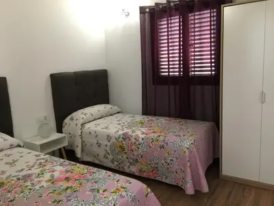 a bedroom with two beds and a window at Las Casitas in Conil de la Frontera
