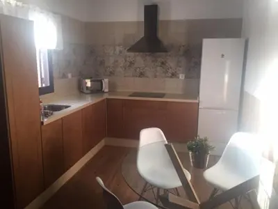 a kitchen with two white chairs and a table at Las Casitas in Conil de la Frontera