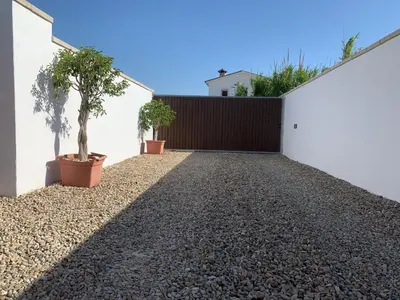 a driveway of a house with a fence and plants at Las Casitas in Conil de la Frontera