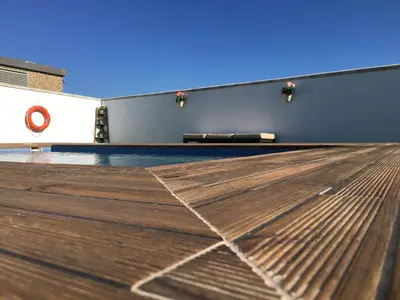 a tennis court with a wooden floor in front of a building at Las Casitas in Conil de la Frontera