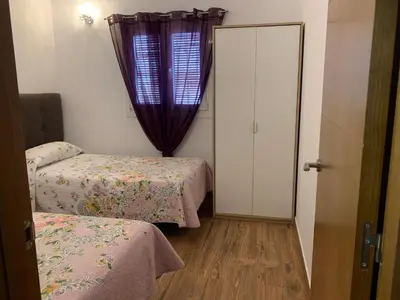a small room with two beds and a window at Las Casitas in Conil de la Frontera