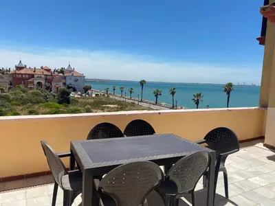 a table and chairs on a balcony with a view of the ocean at Apartamento terraza puerto sherry. in El Puerto de Santa María