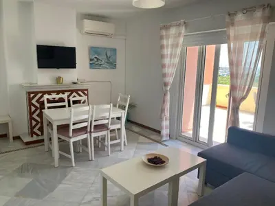 a living room with a table and a dining room at Apartamento terraza puerto sherry. in El Puerto de Santa María
