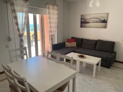 a living room with a couch and a table at Apartamento terraza puerto sherry. in El Puerto de Santa María