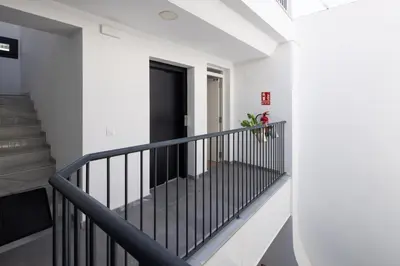 a staircase in a house with white walls and a black door at El Sol & la Sal de Cádiz Little Apartments in Cádiz