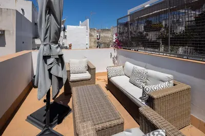 a balcony with a couch and chairs on a roof at El Sol & la Sal de Cádiz Little Apartments in Cádiz