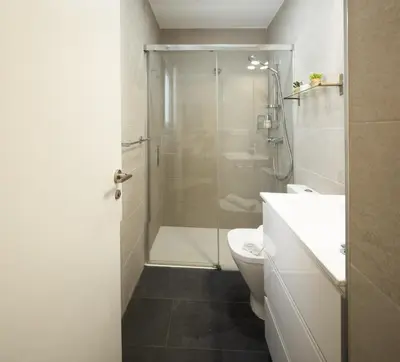 a bathroom with a shower and a toilet and a sink at El Sol & la Sal de Cádiz Little Apartments in Cádiz