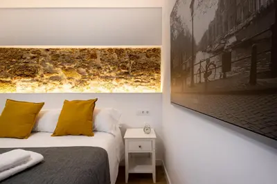 a bedroom with a bed and a picture on the wall at El Sol & la Sal de Cádiz Little Apartments in Cádiz