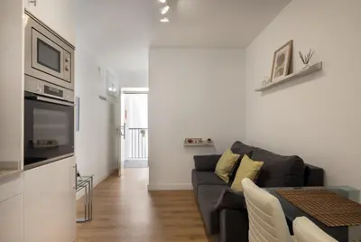 a living room with a couch and a table at El Sol & la Sal de Cádiz Little Apartments in Cádiz