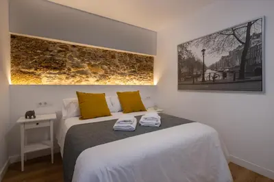 a bedroom with a bed with two towels on it at El Sol & la Sal de Cádiz Little Apartments in Cádiz