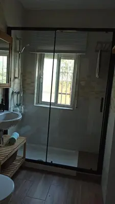 a bathroom with a glass shower and a sink at Villa Antonia in Chipiona