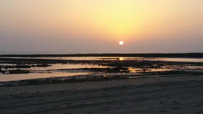 a sunset on the beach with the sun setting at Villa Antonia in Chipiona