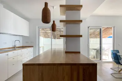 a kitchen with white cabinets and a wooden island at INFINITY Sunny Home by Cadiz4Rentals in Cádiz
