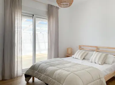 a white bedroom with a bed and a large window at INFINITY Sunny Home by Cadiz4Rentals in Cádiz
