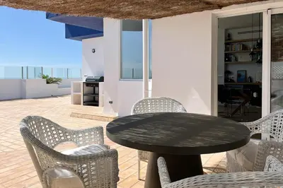 a table and chairs on a patio with a view of the ocean at INFINITY Sunny Home by Cadiz4Rentals in Cádiz