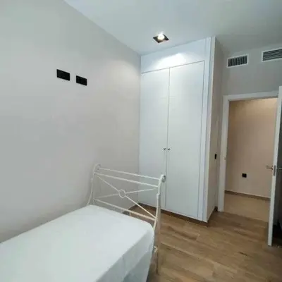 a white bedroom with a bed and a closet at Estupendo Piso Nuevo en Playa Victoria in Cádiz