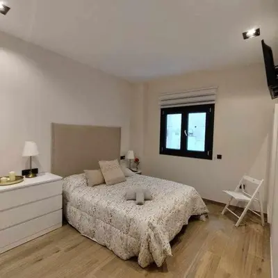 a bedroom with a large bed and a window at Estupendo Piso Nuevo en Playa Victoria in Cádiz