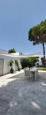 a patio with a table and chairs and a tree at Villa Yoli 26 con Piscina y Jardin cerca de la Playa in Chiclana de la Frontera