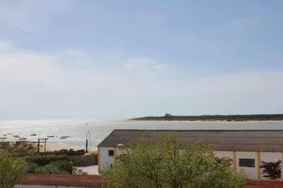 a building next to a body of water at MonKeys Apartments Sanlúcar Beach Relax in Sanlúcar de Barrameda