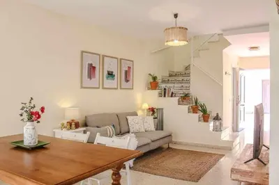 a living room with a couch and a staircase at MonKeys Apartments Sanlúcar Beach Relax in Sanlúcar de Barrameda