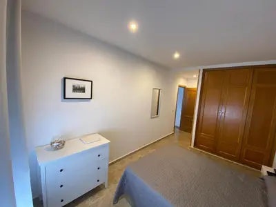 a bedroom with a bed and a dresser and a closet at Apartamento Tía Maria in Cádiz
