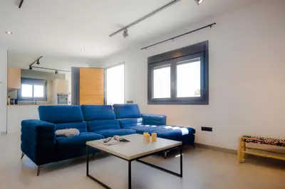a living room with a blue couch and a table at Villa Minerva in Chiclana de la Frontera
