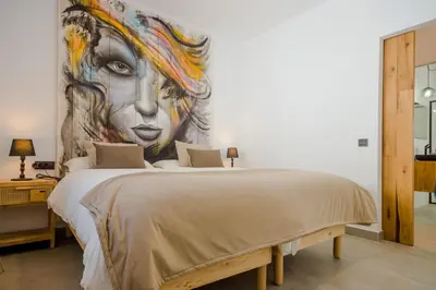 a bedroom with a large painting of a woman at Villa Minerva in Chiclana de la Frontera