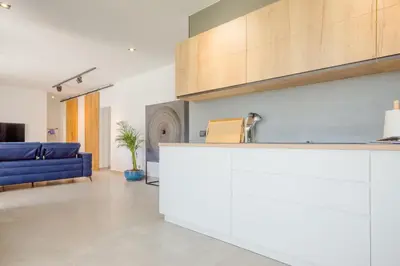a kitchen and living room with a blue couch at Villa Minerva in Chiclana de la Frontera