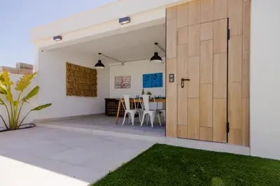 a pivot door to a patio with a table and chairs at Villa Minerva in Chiclana de la Frontera
