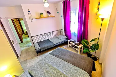 a small room with a bed and a mirror at Plaza de Cárcel 3-bedroom Apartment in El Puerto de Santa María