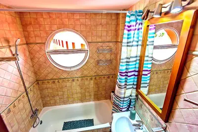 a bathroom with a tub and a sink and a mirror at Plaza de Cárcel 3-bedroom Apartment in El Puerto de Santa María