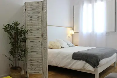 a bedroom with a bed and a wooden partition at Encanto de la Catedral Ha Loft in Cádiz