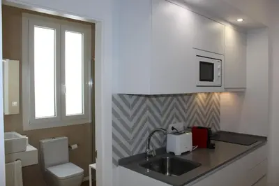 a bathroom with a sink and a toilet and a window at Encanto de la Catedral Ha Loft in Cádiz