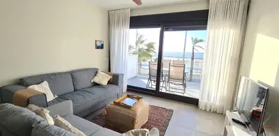 a living room with a couch and a view of the ocean at Arenas de Doñana by Sanlúcar Housing in Sanlúcar de Barrameda