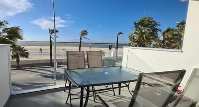 a table and chairs on a balcony with a view of the beach at Arenas de Doñana by Sanlúcar Housing in Sanlúcar de Barrameda