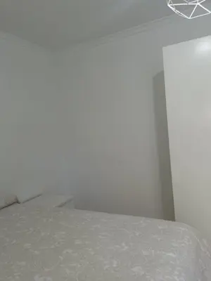 a bedroom with a bed and a white wall at Apartamento Cream MRZ Rentals in Jerez de la Frontera