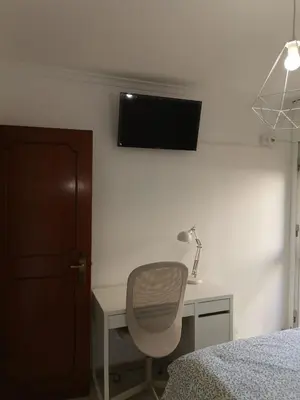 a bedroom with a desk and a chair and a television at Apartamento Cream MRZ Rentals in Jerez de la Frontera