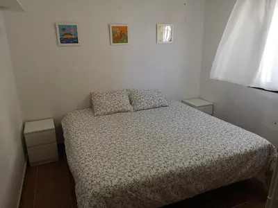 a bedroom with a bed with two pillows and a window at Casa Alma in Conil de la Frontera