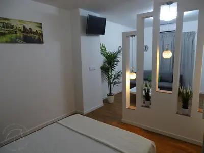 a bedroom with a white bed with two green pillows at Casas jerezanas Loft Olivier in Jerez de la Frontera