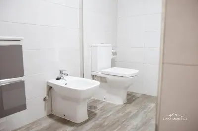 a white bathroom with a toilet and a sink at JEREZ FERIA in Jerez de la Frontera