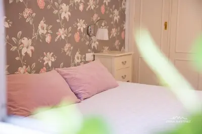 a bedroom with a bed with a pink pillow at JEREZ FERIA in Jerez de la Frontera