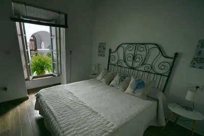 a bedroom with a large white bed with a window at La Fuente Apartamento Jerez in Jerez de la Frontera